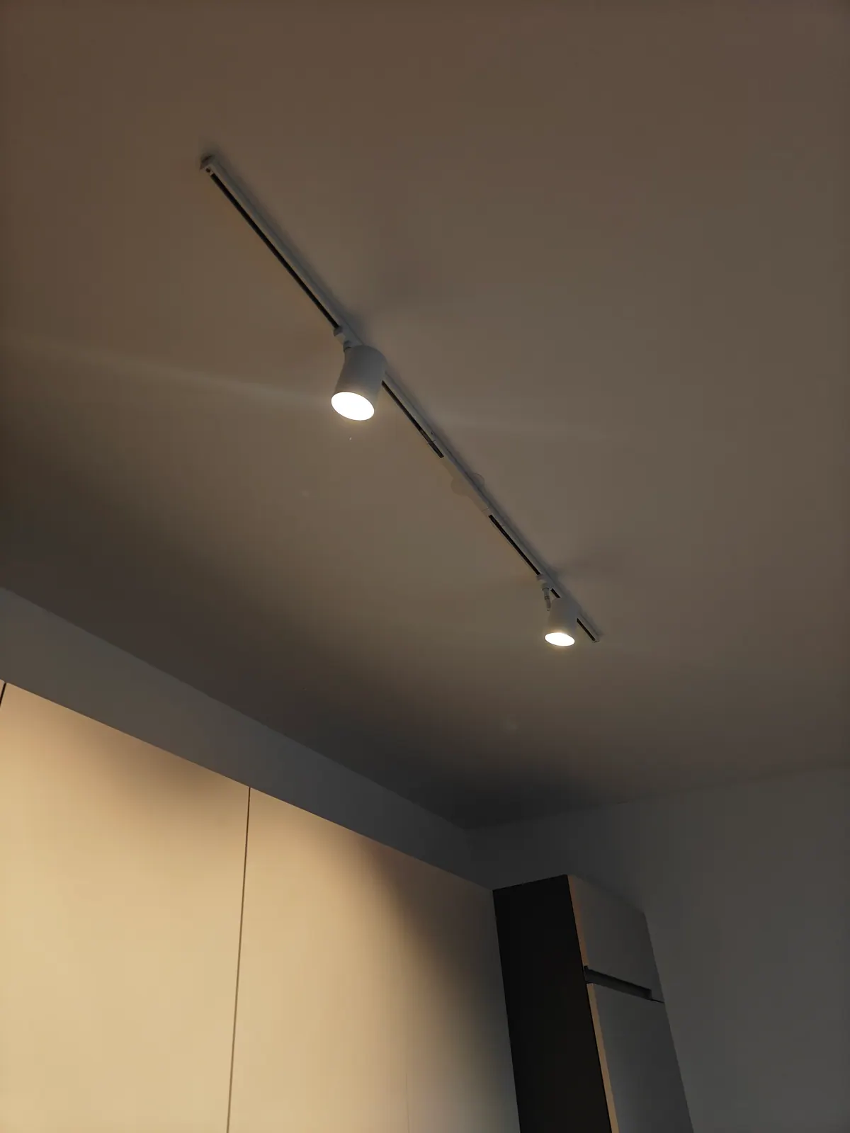 Weißes Deckenschienensystem mit zwei eingeschalteten LED-Spots