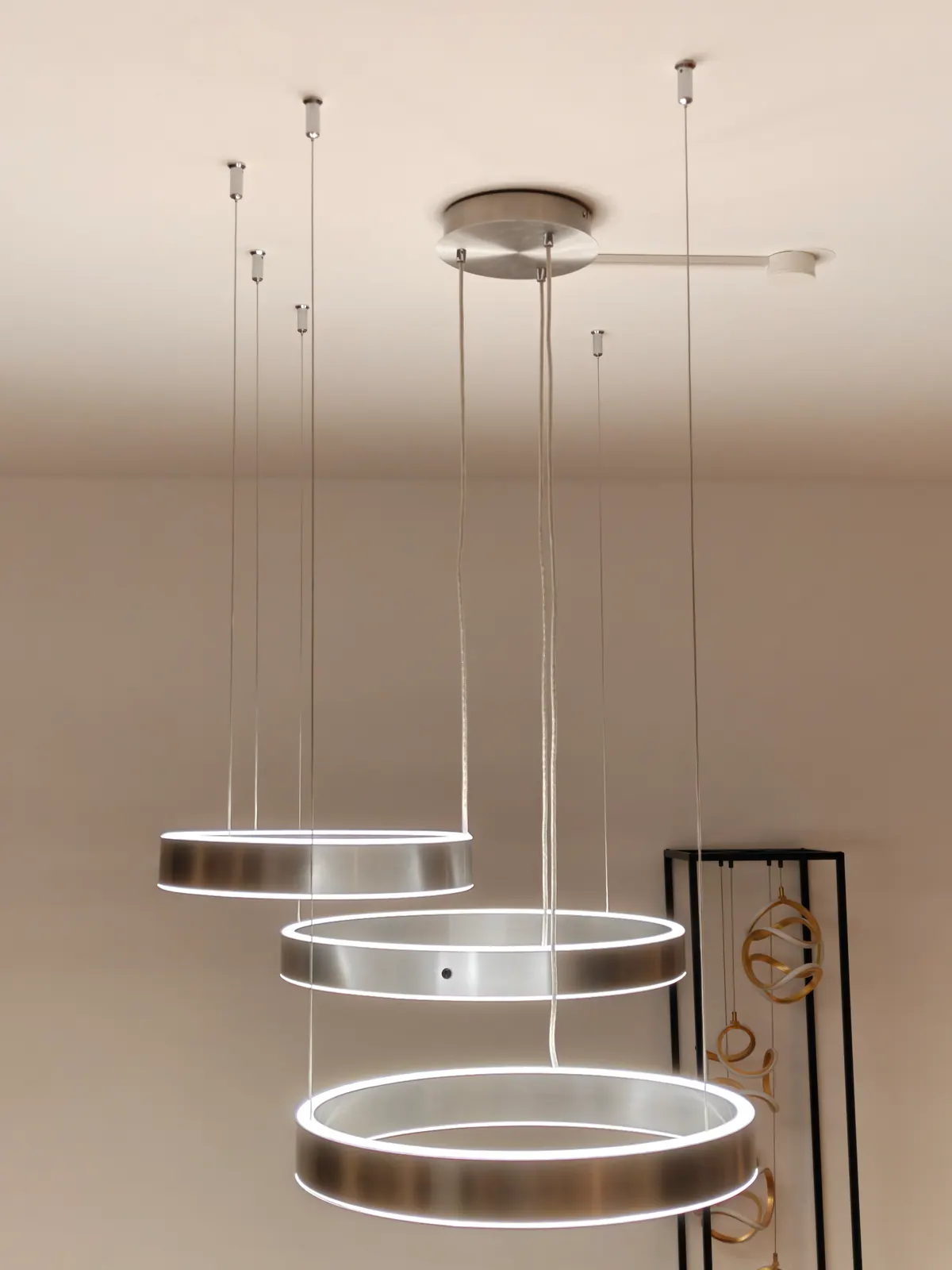 Drei runde LED-Ringlampen gestaffelt an der Decke