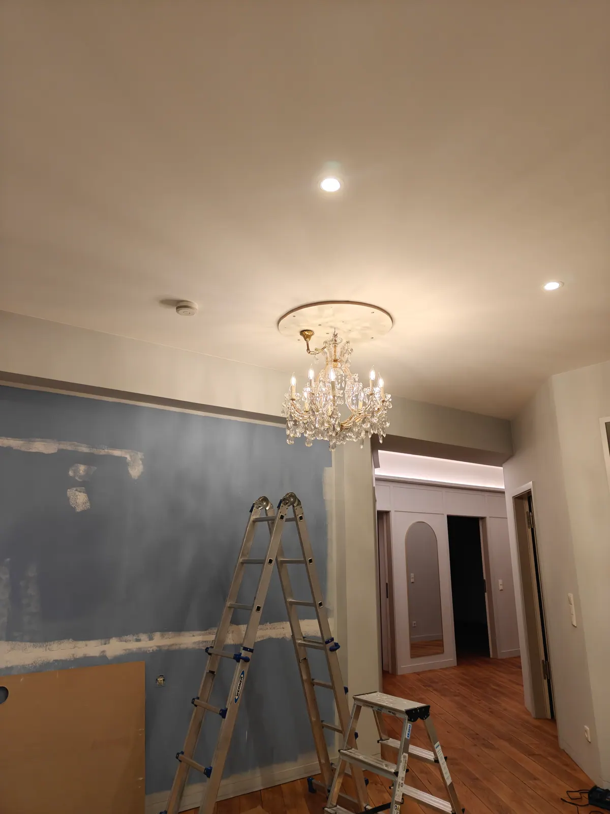 Mehrstufiger Kristallkronleuchter an weißer Decke